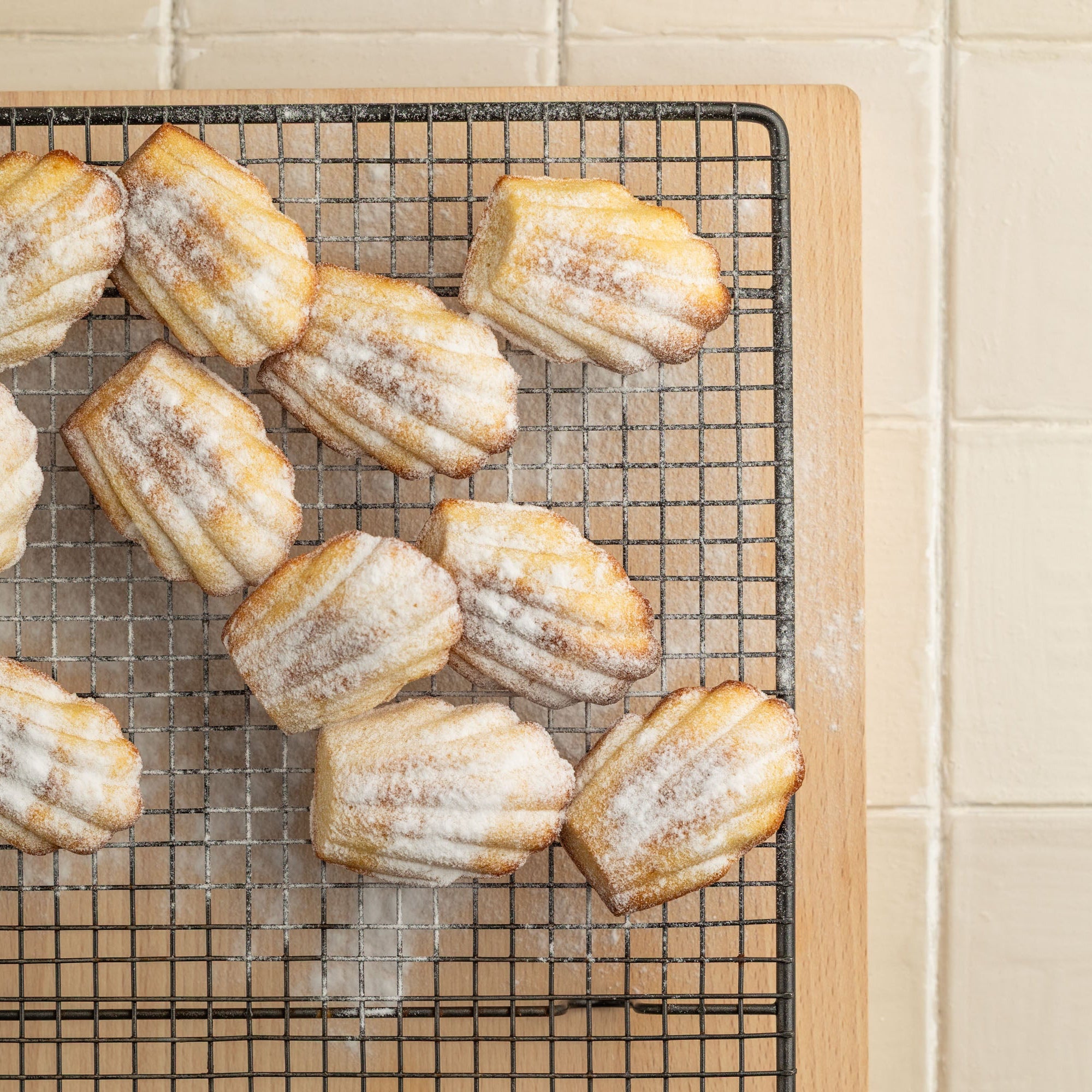 Baked pastries on a cooling rack against a tiled wall.