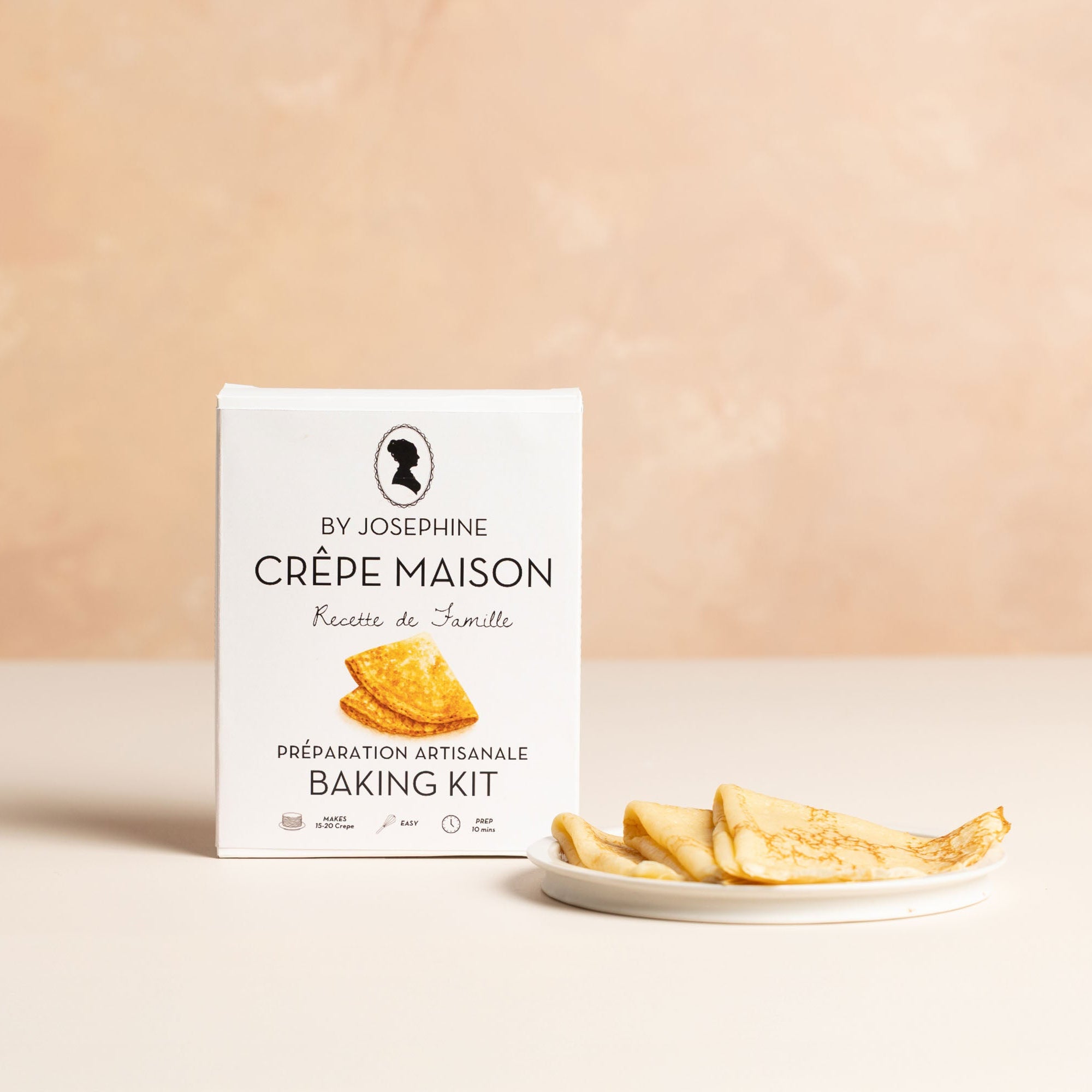 Baking kit packaging for crèpes with a plate of crèpes on a beige background